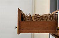 Open filing cabinet drawer filled with papers 